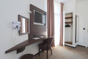 a room with a desk with a mirror and a chair at Hôtel Annexe in Nice
