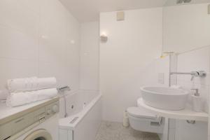 ein weißes Bad mit einem Waschbecken und einem WC in der Unterkunft Bright Penthaus Apartement, with a wonderful view in Ljubljana