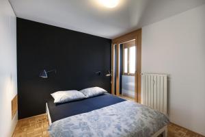 ein Schlafzimmer mit einem blauen Bett und einer schwarzen Wand in der Unterkunft Bright Penthaus Apartement, with a wonderful view in Ljubljana
