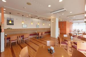 a dining room with wooden tables and chairs at Tabist Yabuki Station Hotel in Yabuki
