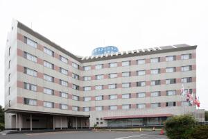 a large hotel building with a clock on top of it at Tabist Yabuki Station Hotel in Yabuki