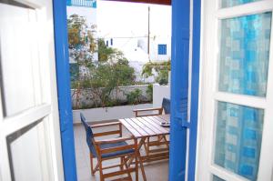 a table and chairs on the balcony of a house at Aegeon Pension in Aegiali