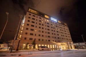 富良野La Vista Furano Hills Natural Hot Spring的夜间标有标志的酒店大楼