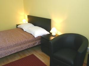 ブダペストにあるArriva Balcony Studioのベッドルーム1室(ベッド1台、椅子、ランプ2つ付)