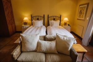 a bedroom with two beds and a couch with pillows at High Timbers Lodge in Tokai