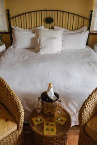 a bed with two chairs and a table with glasses on it at High Timbers Lodge in Tokai