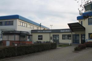 a building with a cafe restaurant in front of it at Pension Take Off in Gera