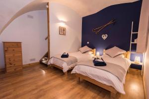 a bedroom with two beds and a clock on the wall at Maison Lennox in Mâcot La Plagne