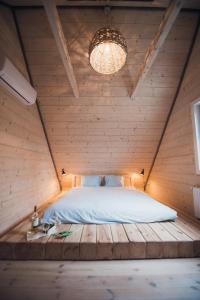 1 dormitorio con 1 cama en una pared de madera en Relax House Narty en Narty