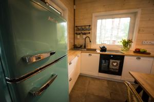 eine Küche mit einem grünen Kühlschrank neben einem Tisch in der Unterkunft Relax House Narty in Narty