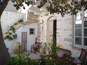 a courtyard of a house with two chairs and a door at En Patmo Holiday Home in Patmos