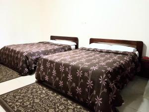 two beds sitting next to each other in a room at Hotel du Golfe de Guinee in Conakry