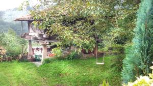 una casa en el árbol con un columpio en un jardín en Apartamentos Villar, en Villar