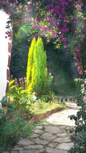 un jardín con flores de colores y un camino de piedra en Apartamentos Villar, en Villar