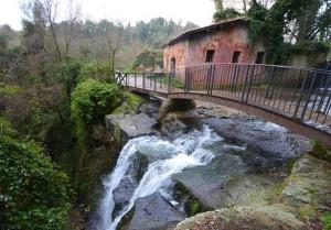 a bridge over a river with a waterfall at Annie's Home in La Giustiniana
