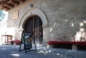 a building with a large wooden door with a sign in front at "Pivnica i smestaj Jovanovic"- Rogljevacke pivnice in Rogljevo