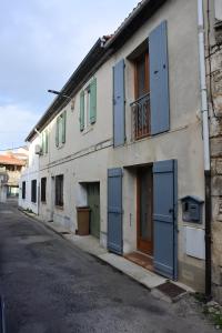 un bâtiment avec des portes et des fenêtres bleues dans une rue dans l'établissement Maison du 14.07, à Arles