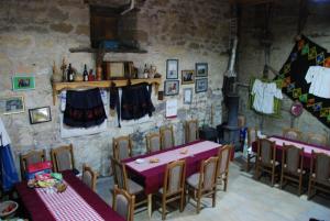a dining room with tables and chairs and a stove at "Pivnica i smestaj Jovanovic"- Rogljevacke pivnice in Rogljevo