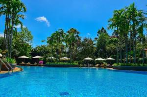 a large swimming pool with palm trees and umbrellas at Borei Angkor Resort & Spa in Siem Reap