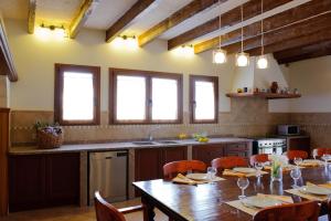 cocina grande con mesa de madera y sillas en Finca Mondrago Duri, en Portopetro