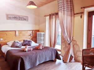 a bedroom with a bed with two teddy bears on it at Auberge des deux Moucherolles in Corrençon-en-Vercors