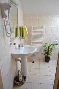 a white bathroom with a sink and a phone at Byron in Zlaté Moravce