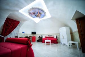sala de estar con sofá rojo y techo en B&B Punto Stella, en Nápoles
