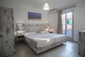 a bedroom with a large bed and a window at Evina Rooms & Suites in Kokkini Khanion