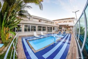 a swimming pool with chairs and a building at FPH Hotel in Aracaju