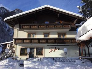 un edificio con nieve delante en Pension Lagler, en Heiligenblut