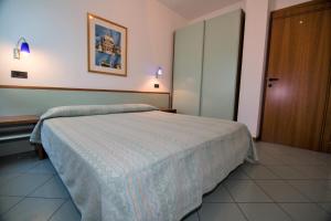 ein Schlafzimmer mit einem großen Bett und einer Tür in der Unterkunft Appartamento Mediterraneo in San Benedetto del Tronto