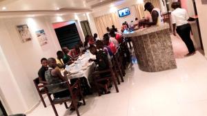 eine Gruppe von Menschen, die an Tischen in einem Restaurant sitzen in der Unterkunft Hotel du Golfe de Guinee in Conakry