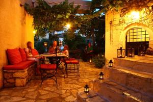 a group of people sitting at a table in a patio at Villa Polyxeni Apartments in Syvota