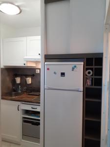 uma cozinha com um frigorífico branco e um fogão em Ysaura em Soustons