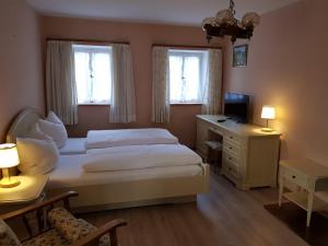 1 Schlafzimmer mit einem Bett, einem Schreibtisch und 2 Fenstern in der Unterkunft Haus Gasserer in Berchtesgaden