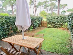 a wooden table with an umbrella on top of it at Ysaura in Soustons