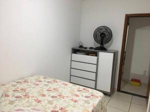 1 dormitorio con 1 cama y ventilador en Suíte e Quarto em apartamento familiar, Praia do Morro!, en Guarapari