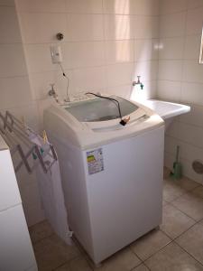 ein weißes Badezimmer mit Waschbecken und Badewanne in der Unterkunft Meu verao em ITAPEMA in Itapema