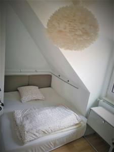 ein kleines Bett in einem Zimmer mit einer Decke in der Unterkunft Wunderschönes Penthouse im Herzen von Hameln in Hameln