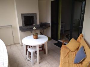 einen kleinen weißen Tisch und Stuhl im Wohnzimmer in der Unterkunft Meu verao em ITAPEMA in Itapema + 9 Fotos