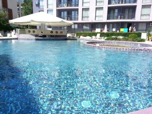 una gran piscina con sombrilla frente a un edificio en Menada Rainbow Apartments, en Sunny Beach