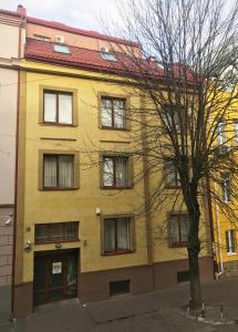a yellow building with a tree in front of it at Hotel 18 in Lviv