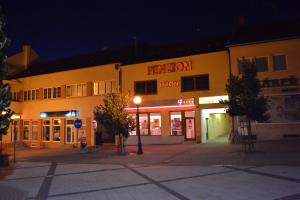 an empty street in front of a building at night at Byron in Zlaté Moravce