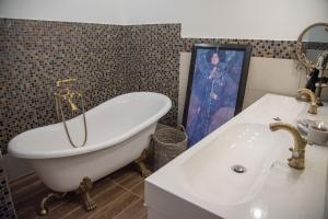 a bathroom with a bath tub and a sink at Anita Home in Gyenesdiás