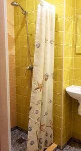 cortina de ducha con conchas en el baño en Bridge Hotel en Riga