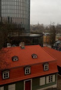 an orange roof on a building with a city in the background at Bridge Hotel in Riga