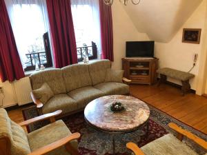 ein Wohnzimmer mit einem Sofa und einem Tisch in der Unterkunft Liebetrau Apartment in Gotha