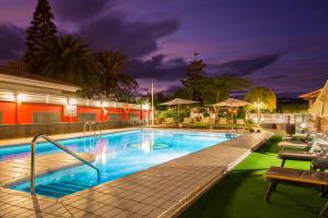 a swimming pool at night with a hotel at Siesta Suites in Maspalomas