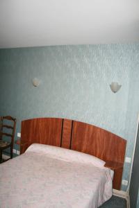 a bedroom with a bed with a wooden head board at Auberge Saint Martin in Saint-Martin-Terressus