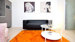 ein Wohnzimmer mit einem schwarzen Sofa und einem Tisch in der Unterkunft Vienna Residence, Alsergrund - AKH in Wien